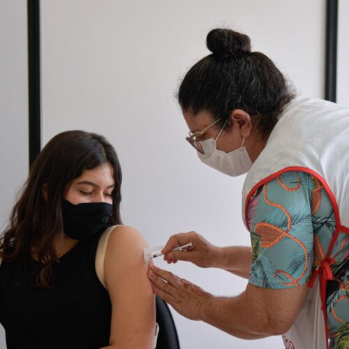 Image of a person being given a COVID vaccine by a clinician
